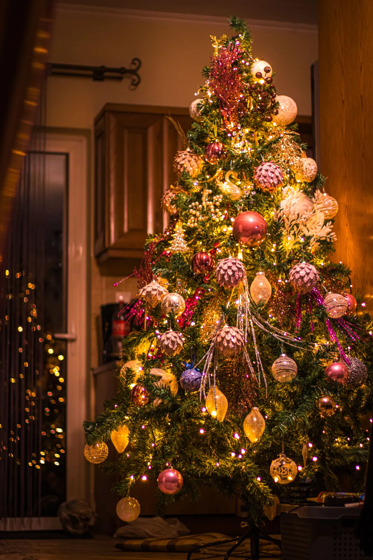 A beautifully decorated Christmas tree with vibrant lights and ornaments indoors.