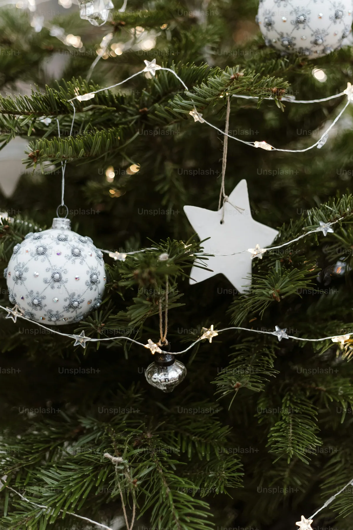 A close up of a christmas tree with ornaments - Photo on Unsplash+