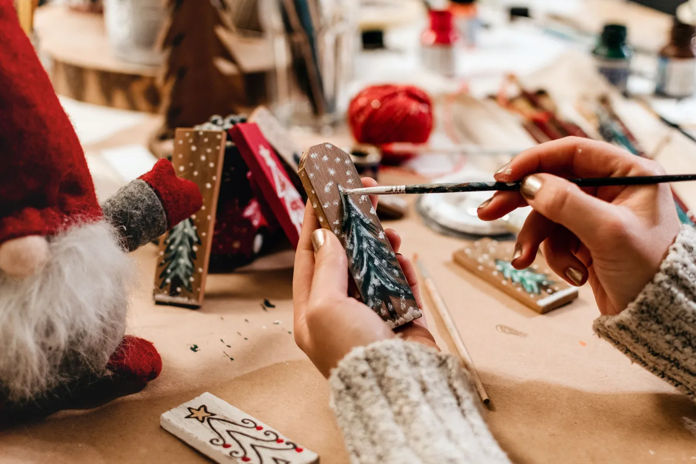 A cozy close-up of holiday crafting with paint and decorations for Christmas.