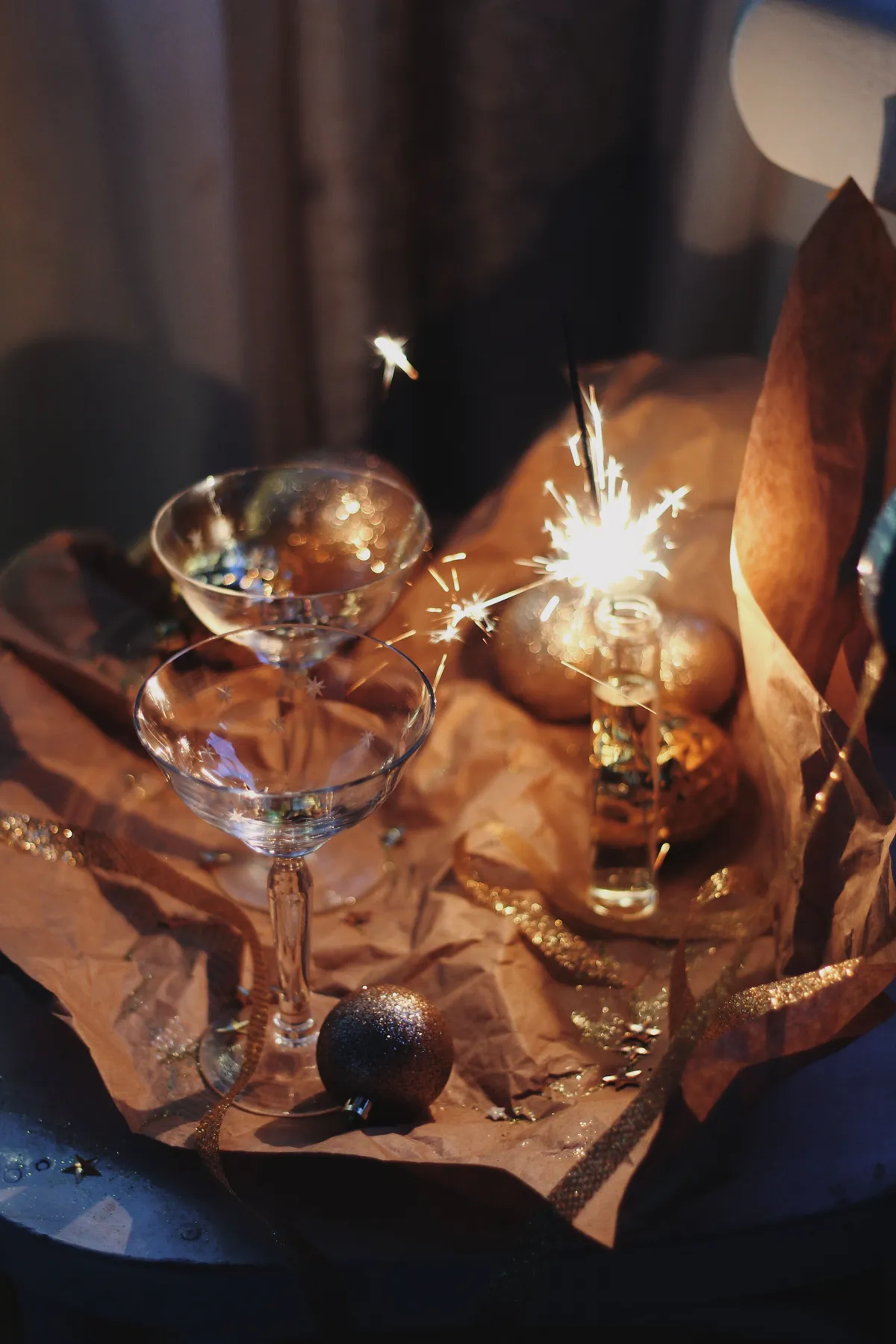 A cozy New Year's Eve setting with sparklers, champagne glasses, and festive decorations.