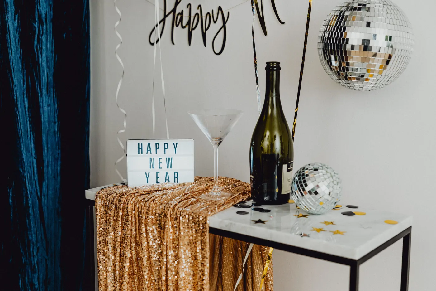 A festive New Year's Eve setup featuring champagne, disco balls, and celebratory decor.