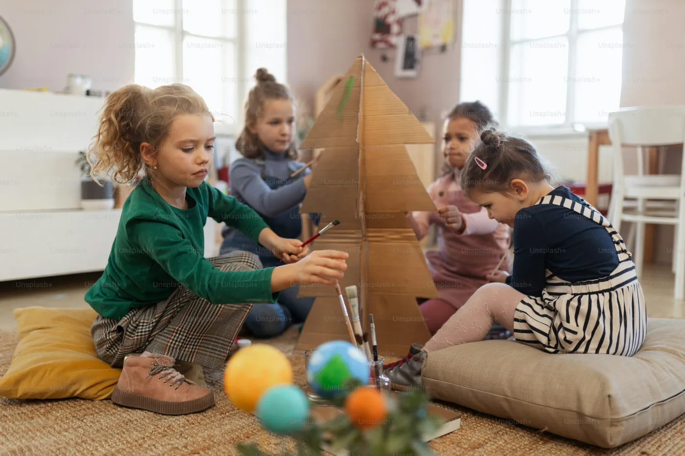 A group of little girls painting cardboard tree at creative art and craft  class at school - Photo on Unsplash+