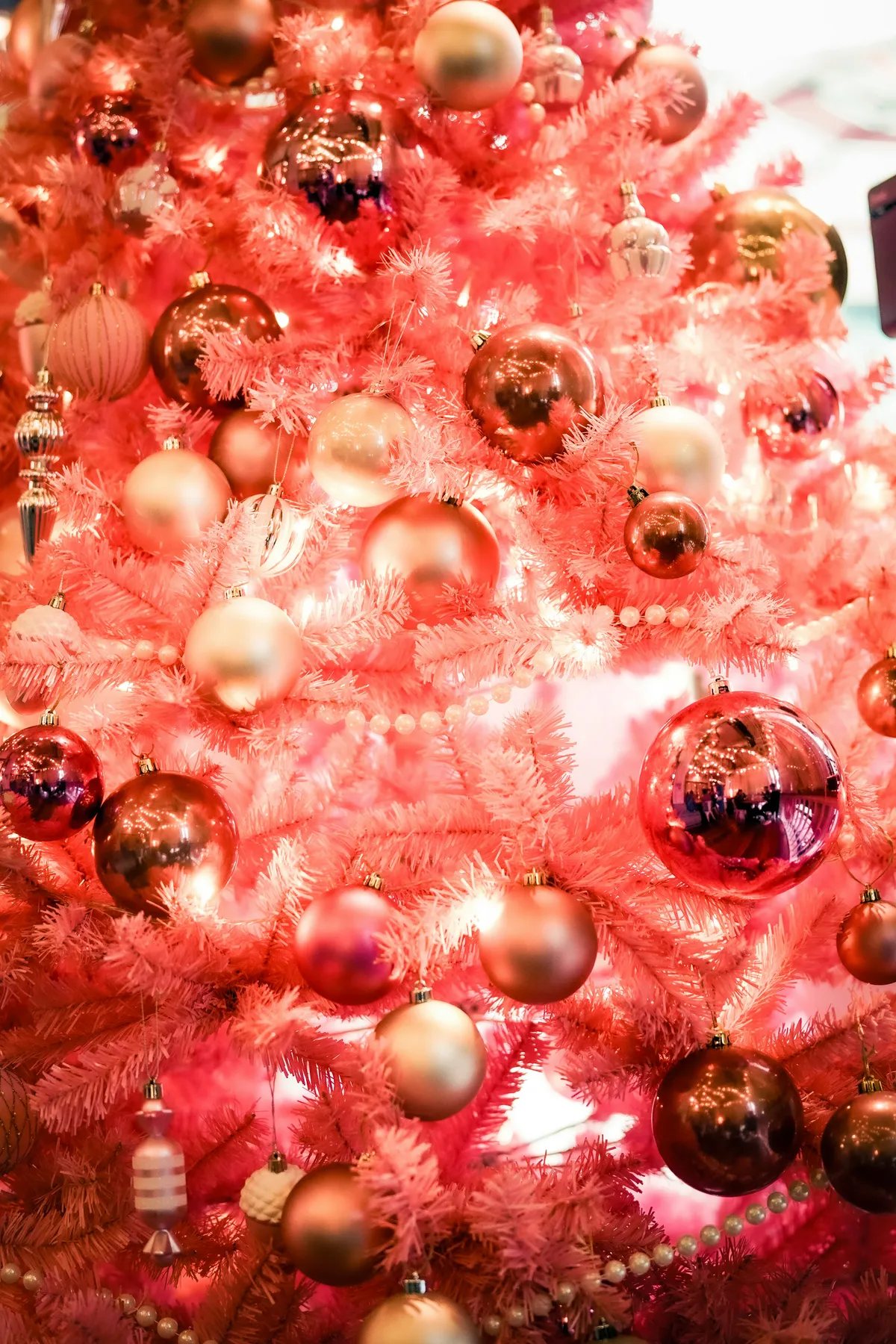 a pink christmas tree with ornaments on it