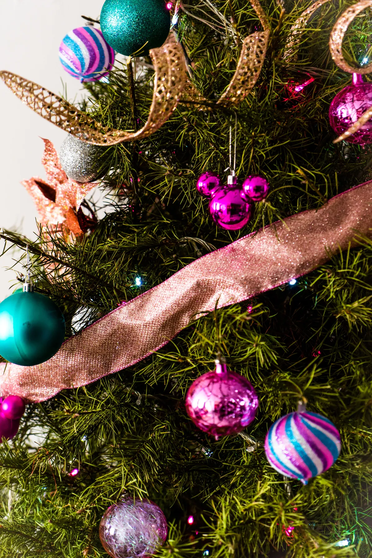A vibrant Christmas tree adorned with diverse ornaments and ribbons, perfect for festive celebrations.