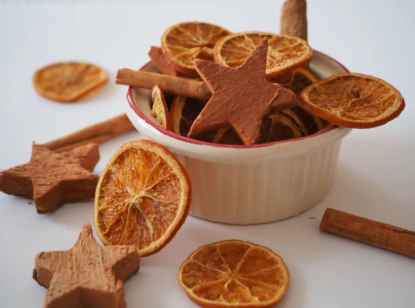 A warm and inviting holiday potpourri arrangement featuring dried oranges, star anise, and cinnamon sticks.