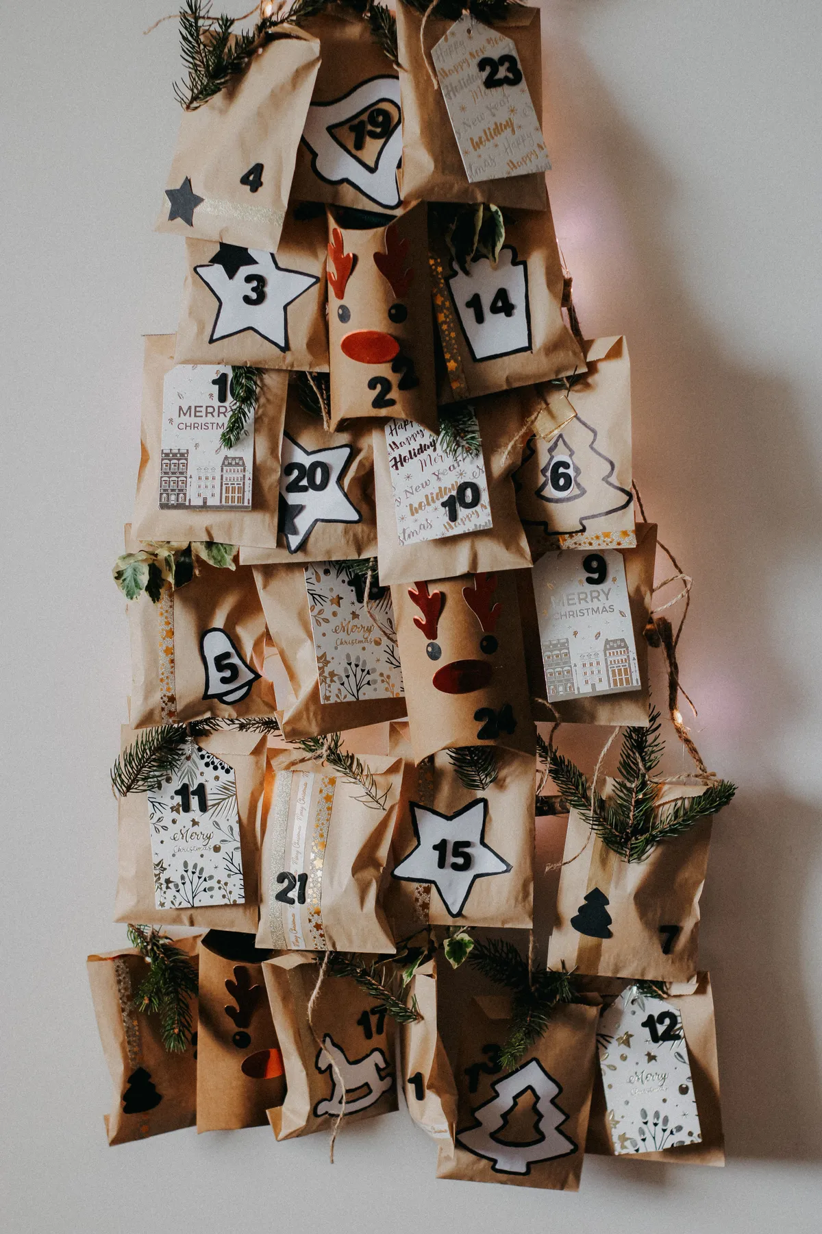 Artistic Christmas advent calendar with numbered pouches and holiday designs on a white background.