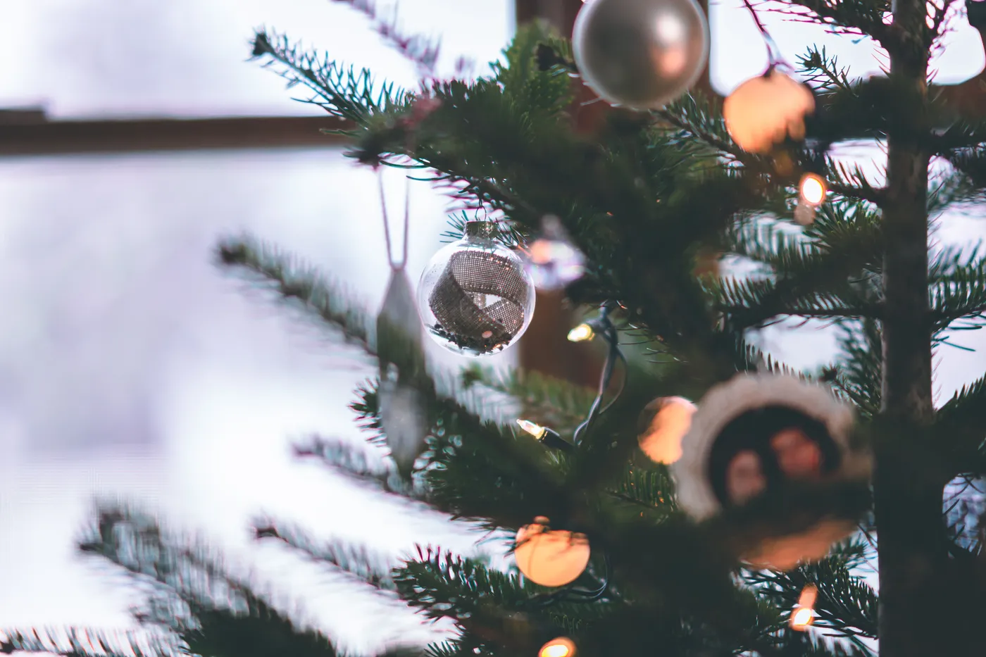 Beautiful Christmas tree adorned with ornaments and lights in a cozy indoor setting.