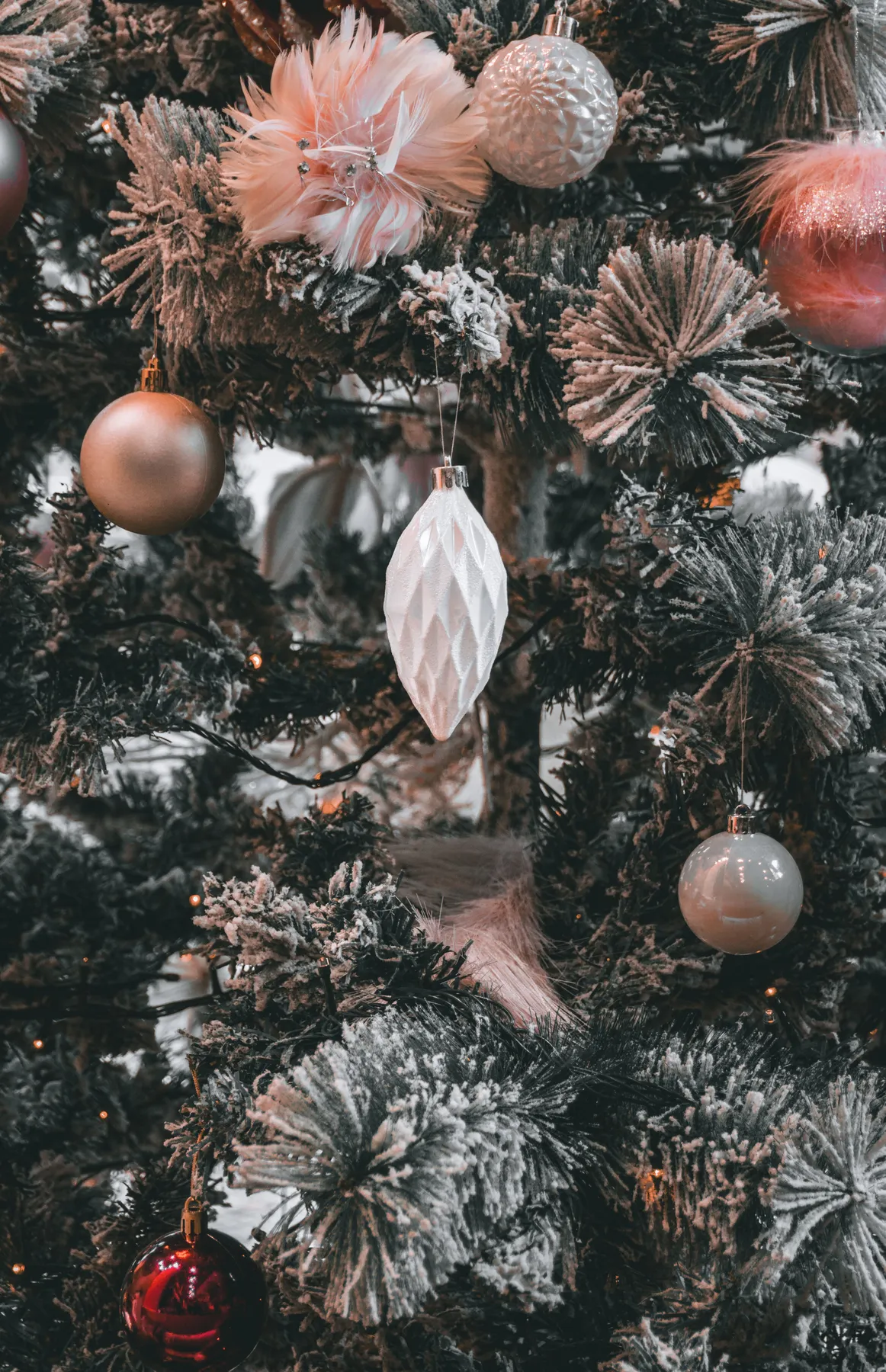 Beautifully decorated Christmas tree with elegant ornaments and snowy branches.