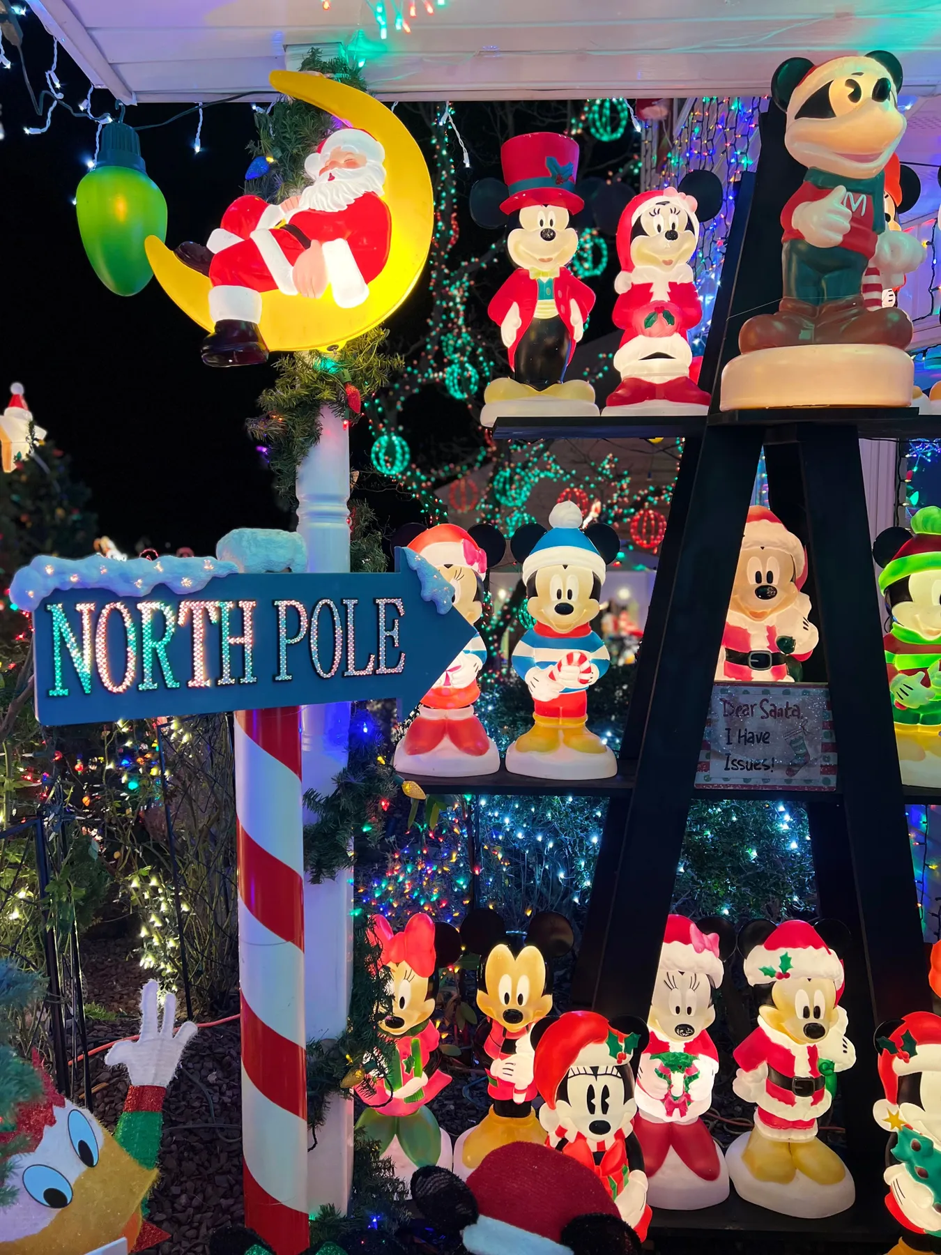Bright and colorful Christmas decorations featuring Mickey Mouse and Santa at night.