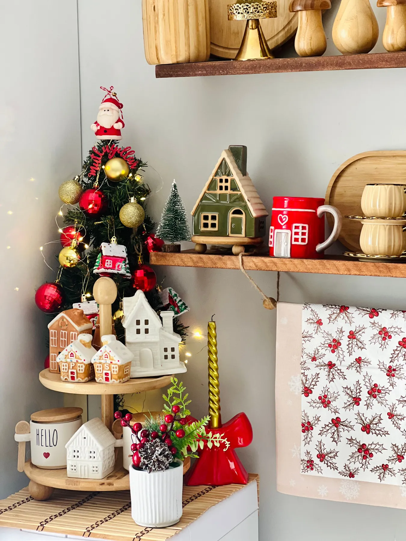 Charming Christmas-themed kitchen shelf with decorations, mugs, and a mini tree.