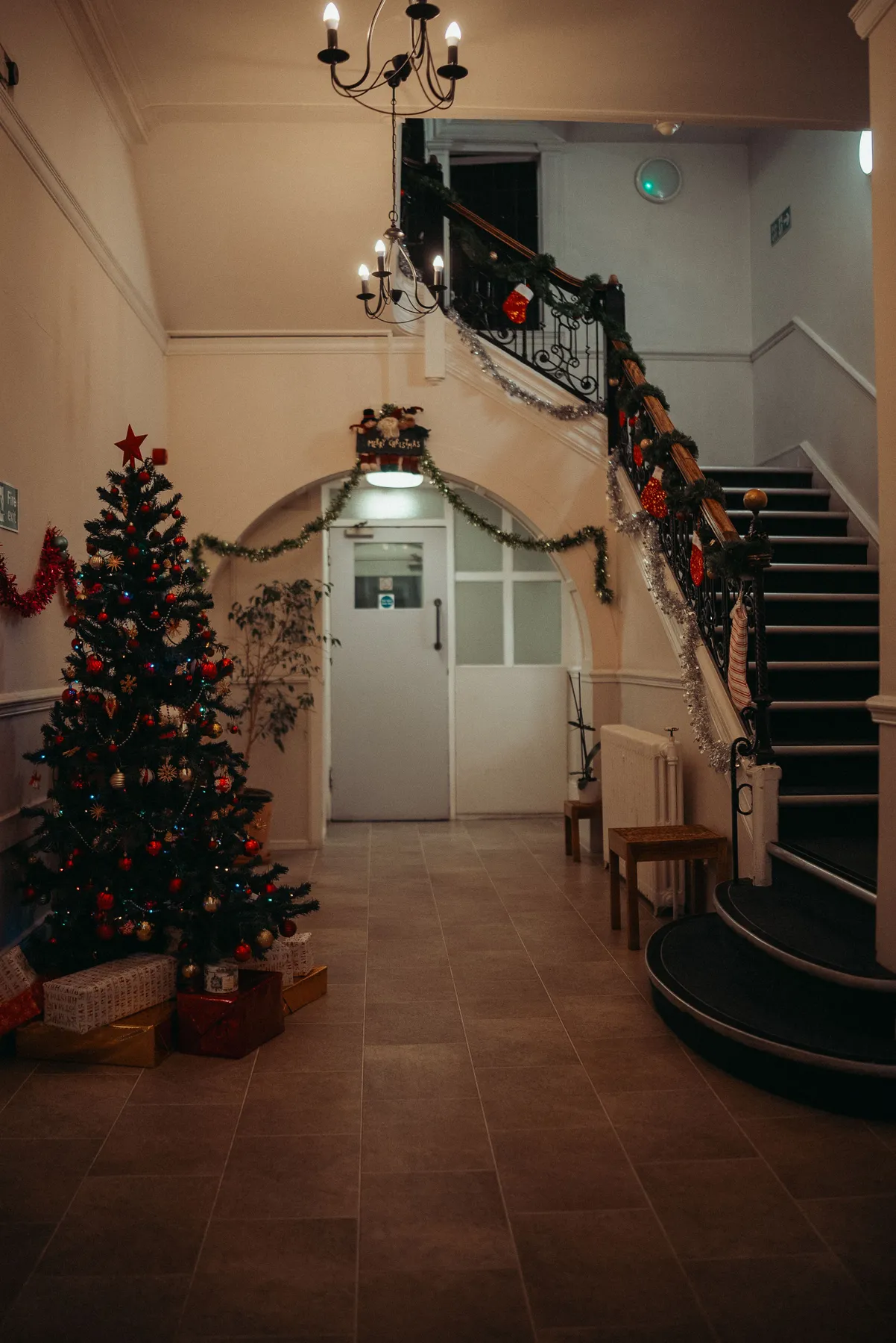 Charming hotel hallway adorned with a Christmas tree and festive decor.