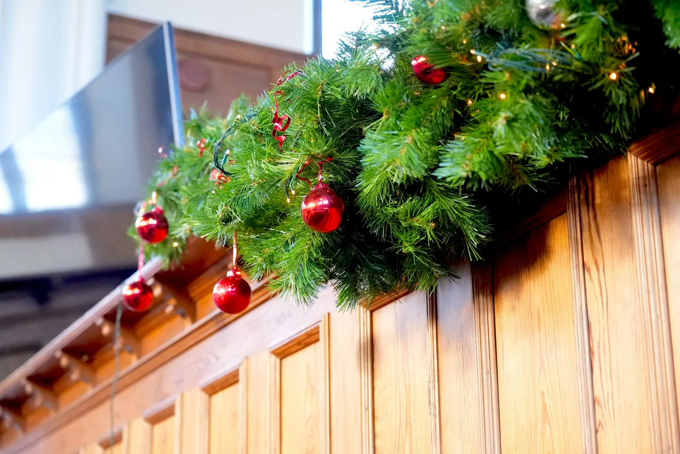 Christmas garland decorates a wooden wall