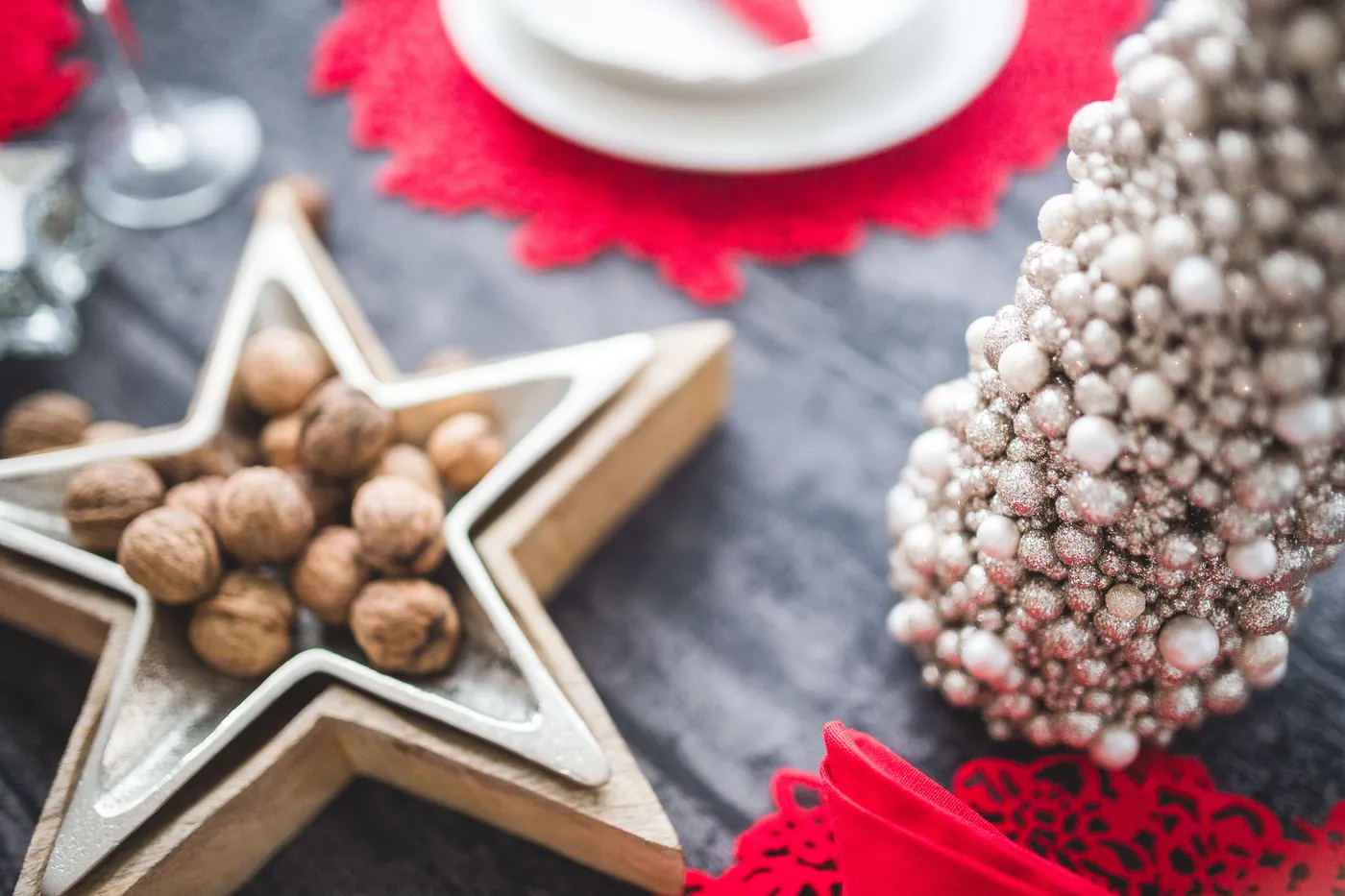 Close-up of a festive Christmas table with a star tray, walnuts, and decorations.
