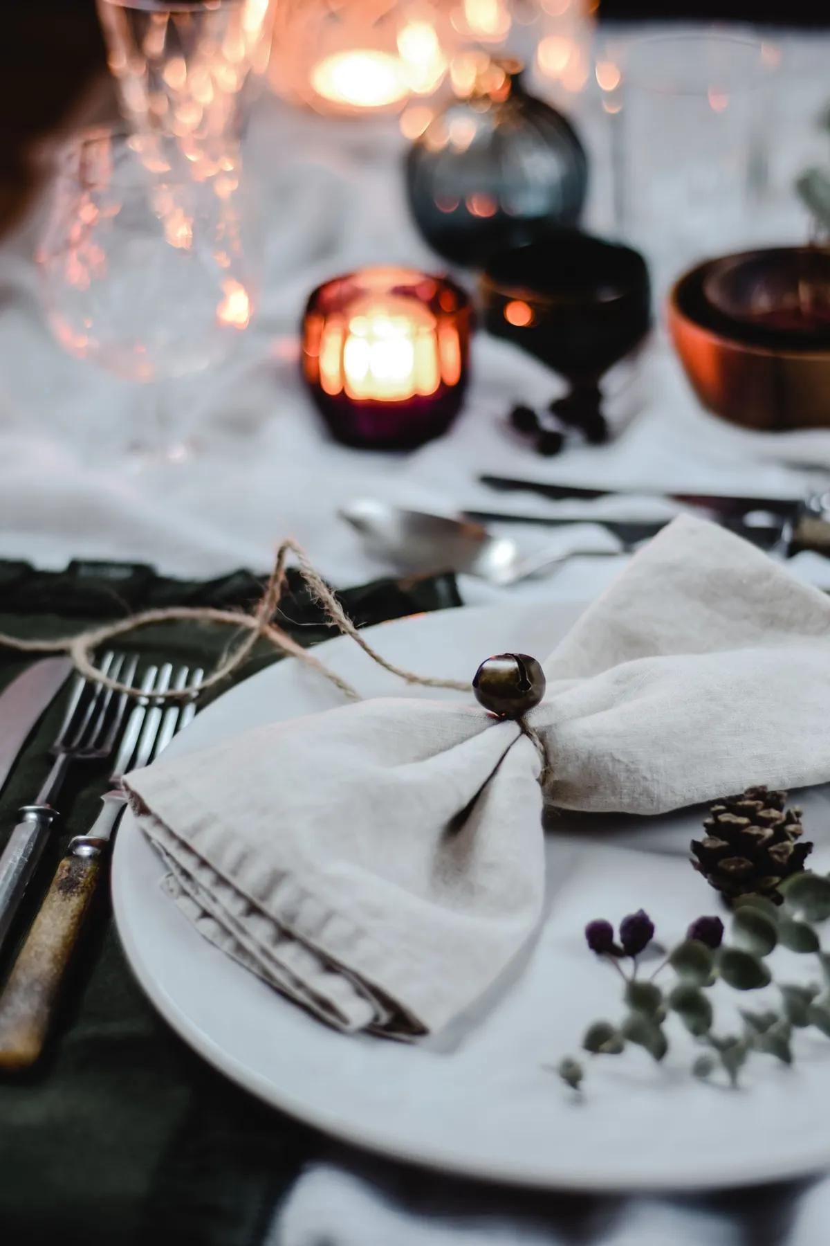 Close-up of a rustic elegant table setting with candles, napkins, and silverware in Helsinki, Finland.