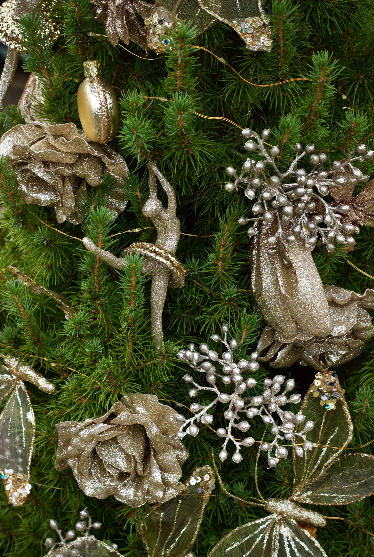 Close-up of an ornate Christmas tree adorned with golden decorations and glittering ornaments.