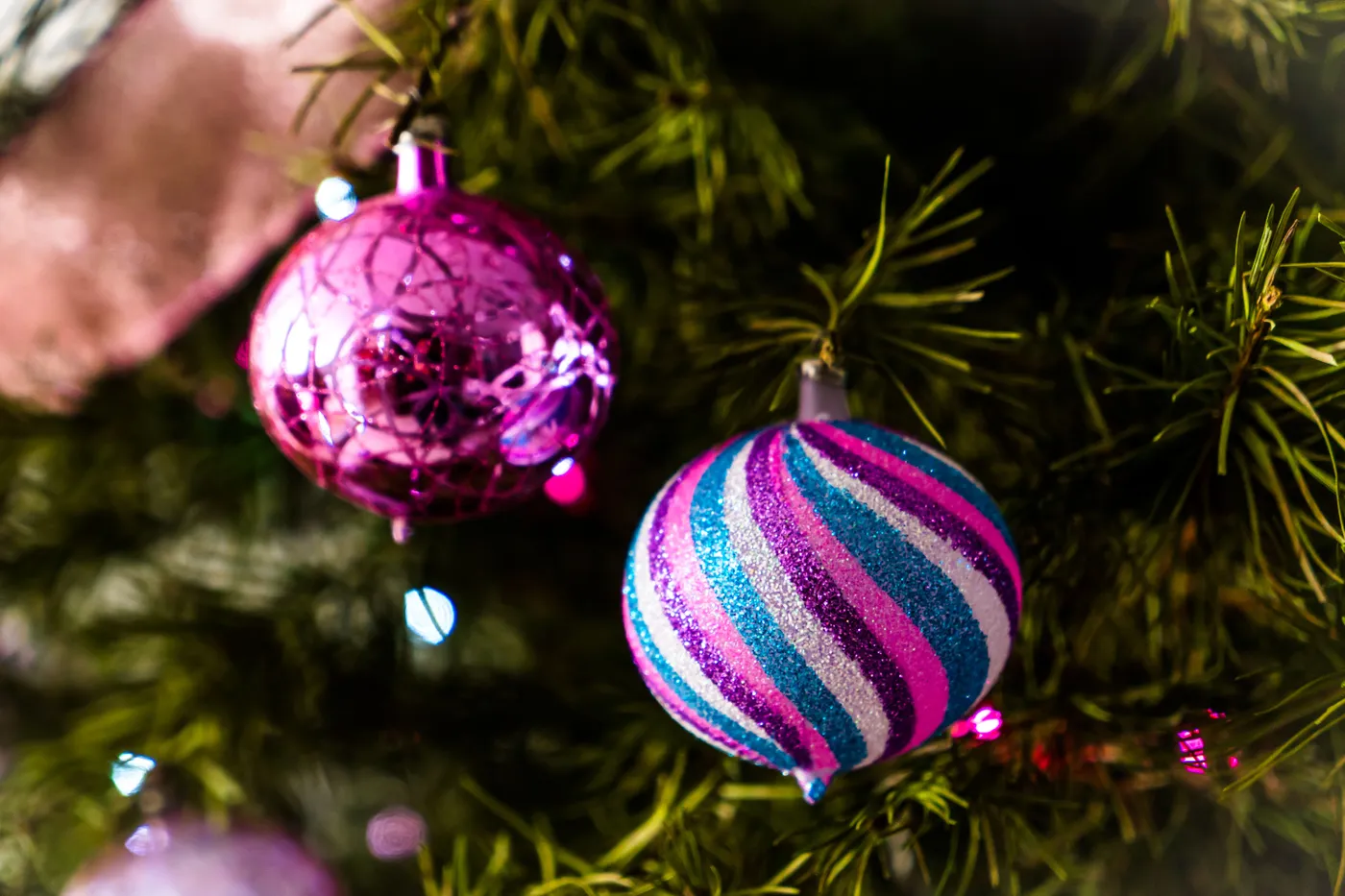 Close-up of colorful Christmas ornaments hanging on a tree, capturing the festive holiday spirit.