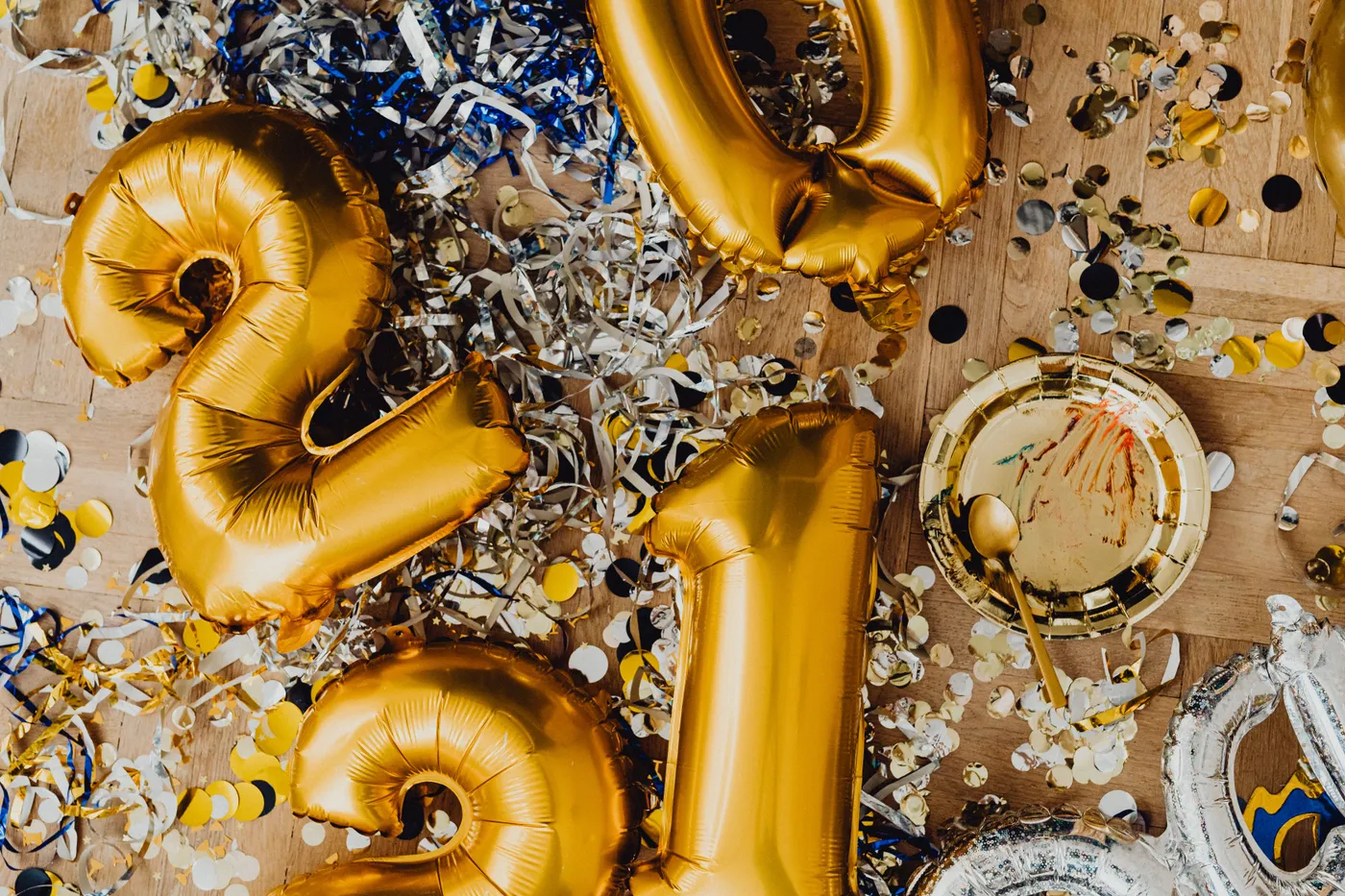 Close-up of gold and silver balloons with confetti, perfect for a festive celebration.
