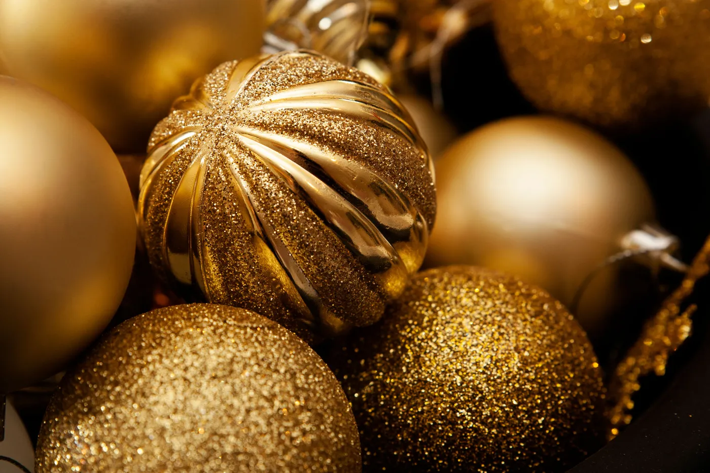 Close-up of gold Christmas ornaments beautifully arranged with glitter detail.