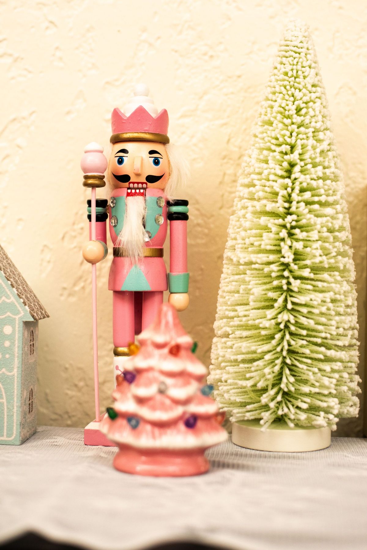 Colorful nutcracker with festive trees creates a charming holiday scene.