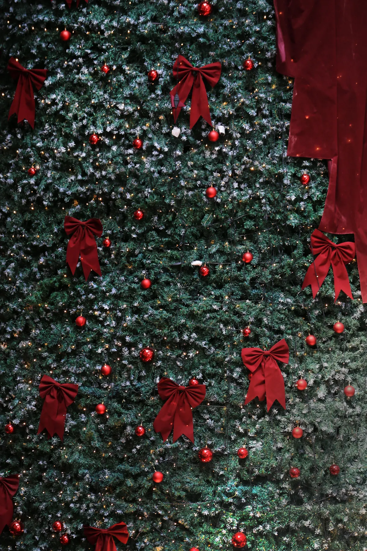 Decorative Christmas tree adorned with red bows and baubles, perfect for holiday celebrations.
