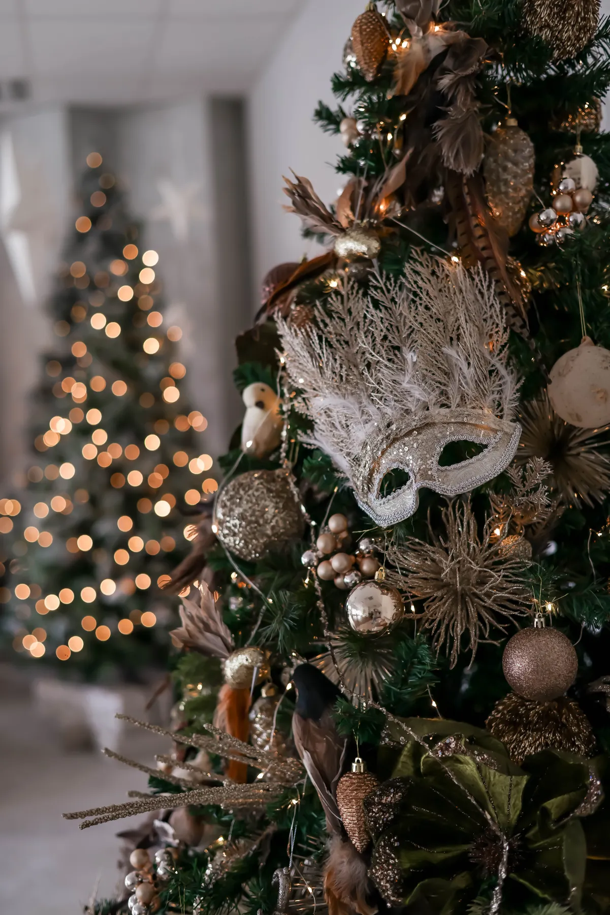 Elegant Christmas tree decorated with golden ornaments and mask, perfect for holiday themes.