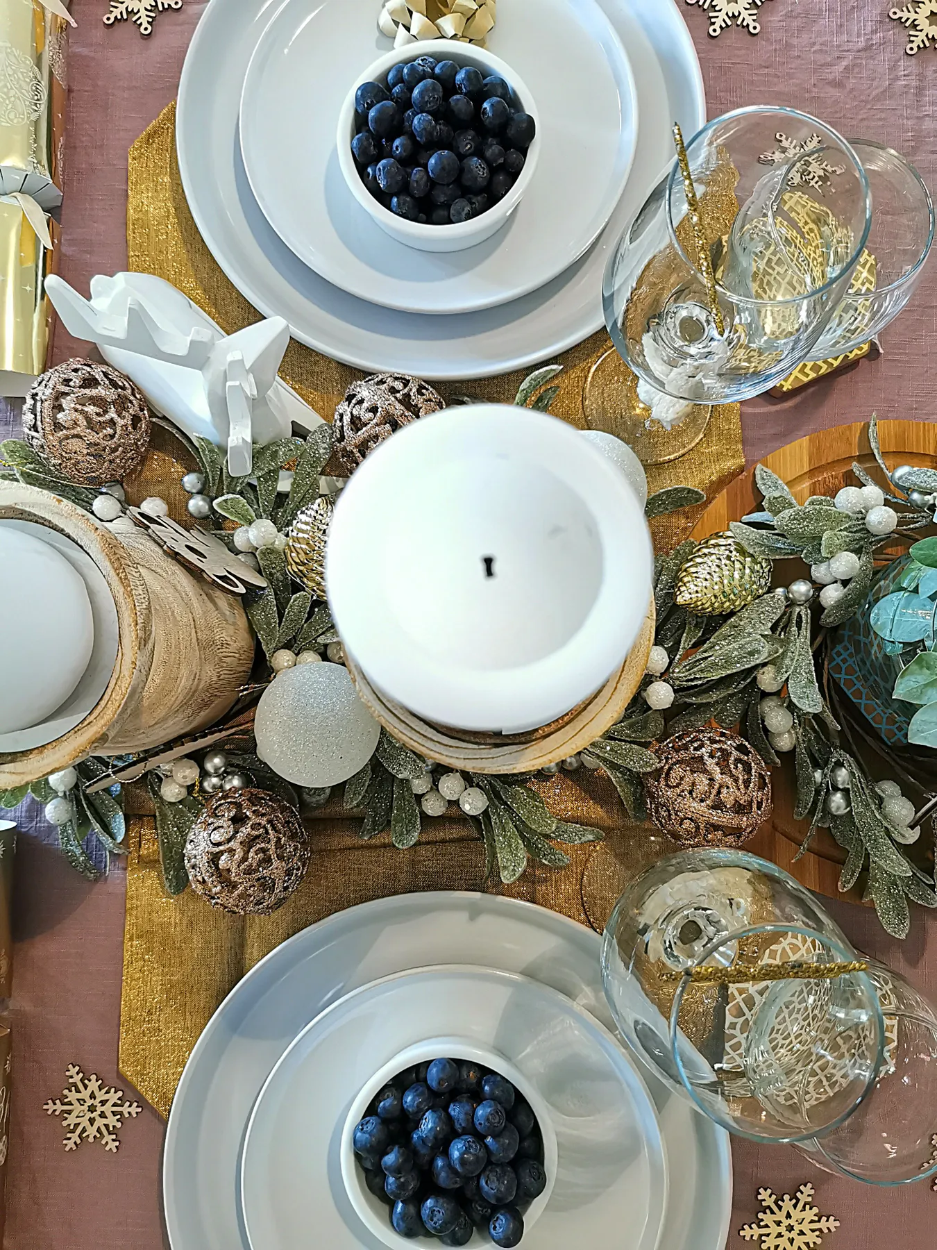 Festive holiday table setting with blueberries and winter decorations.