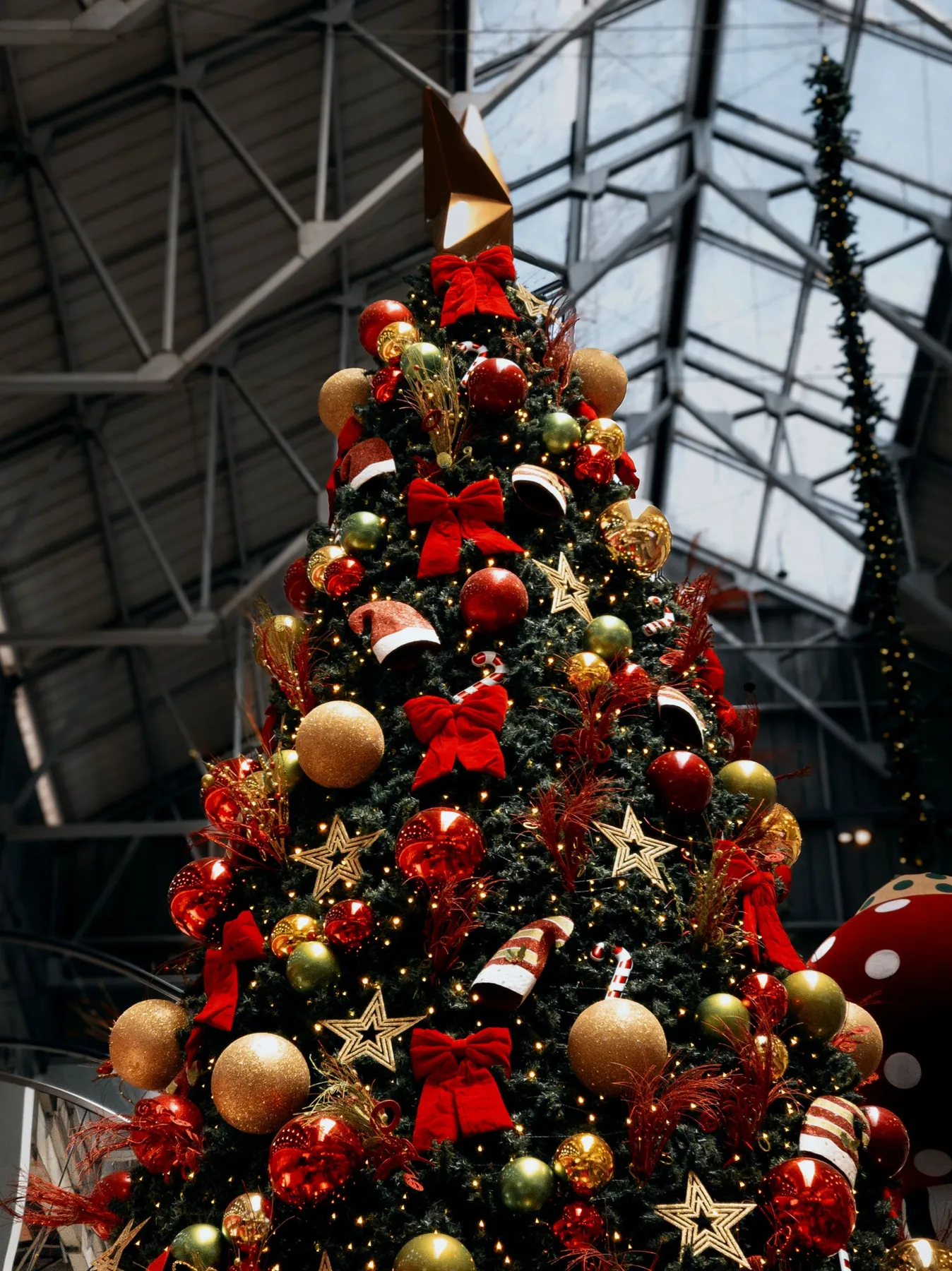 Festively adorned Christmas tree indoors with ornaments and lights.