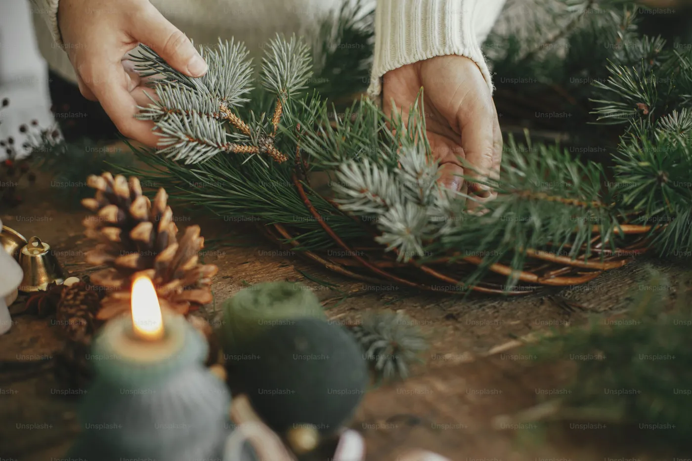 Hands making festive pine wreath - Photo on Unsplash+