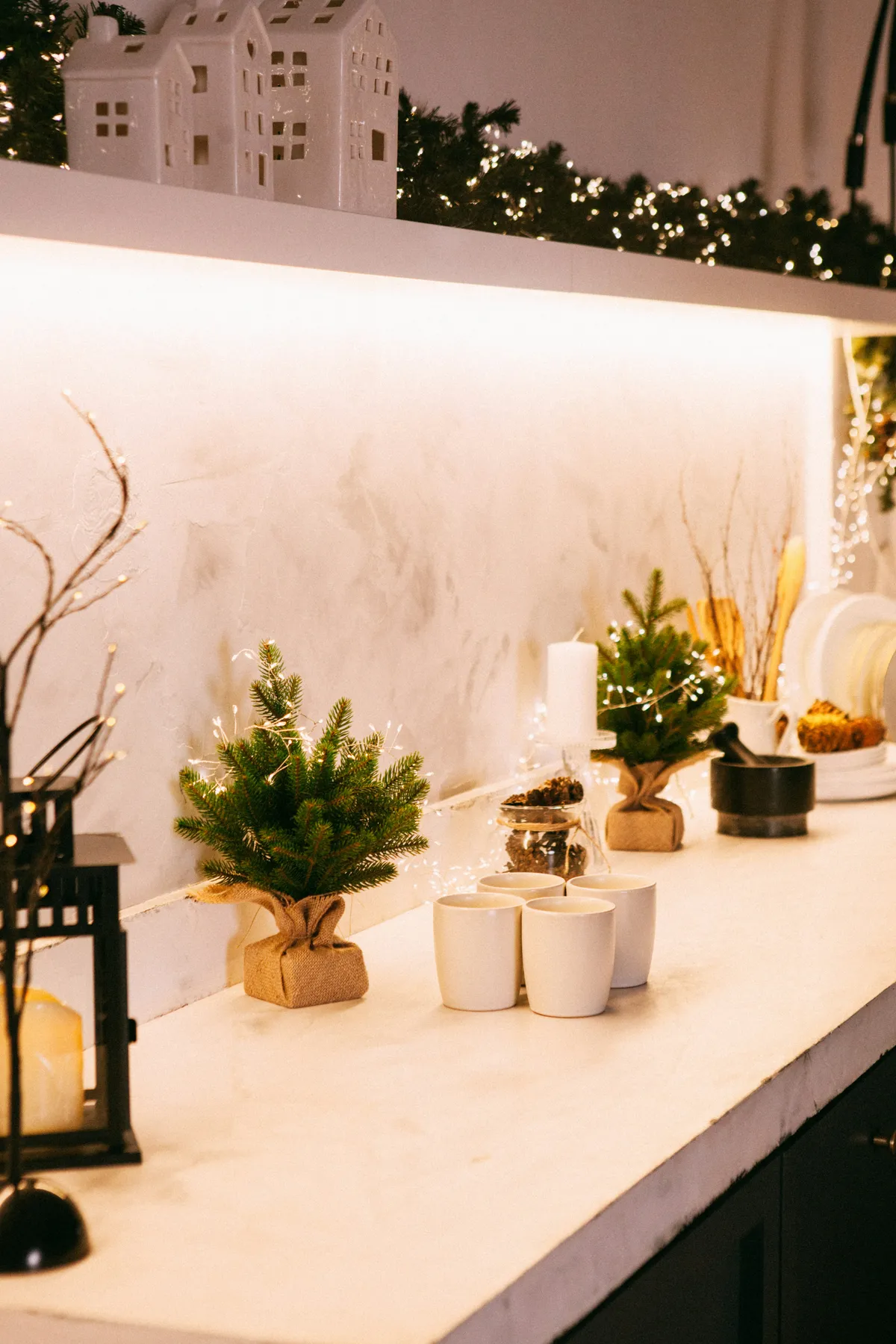 Kitchen counter decorated for christmas with mini trees