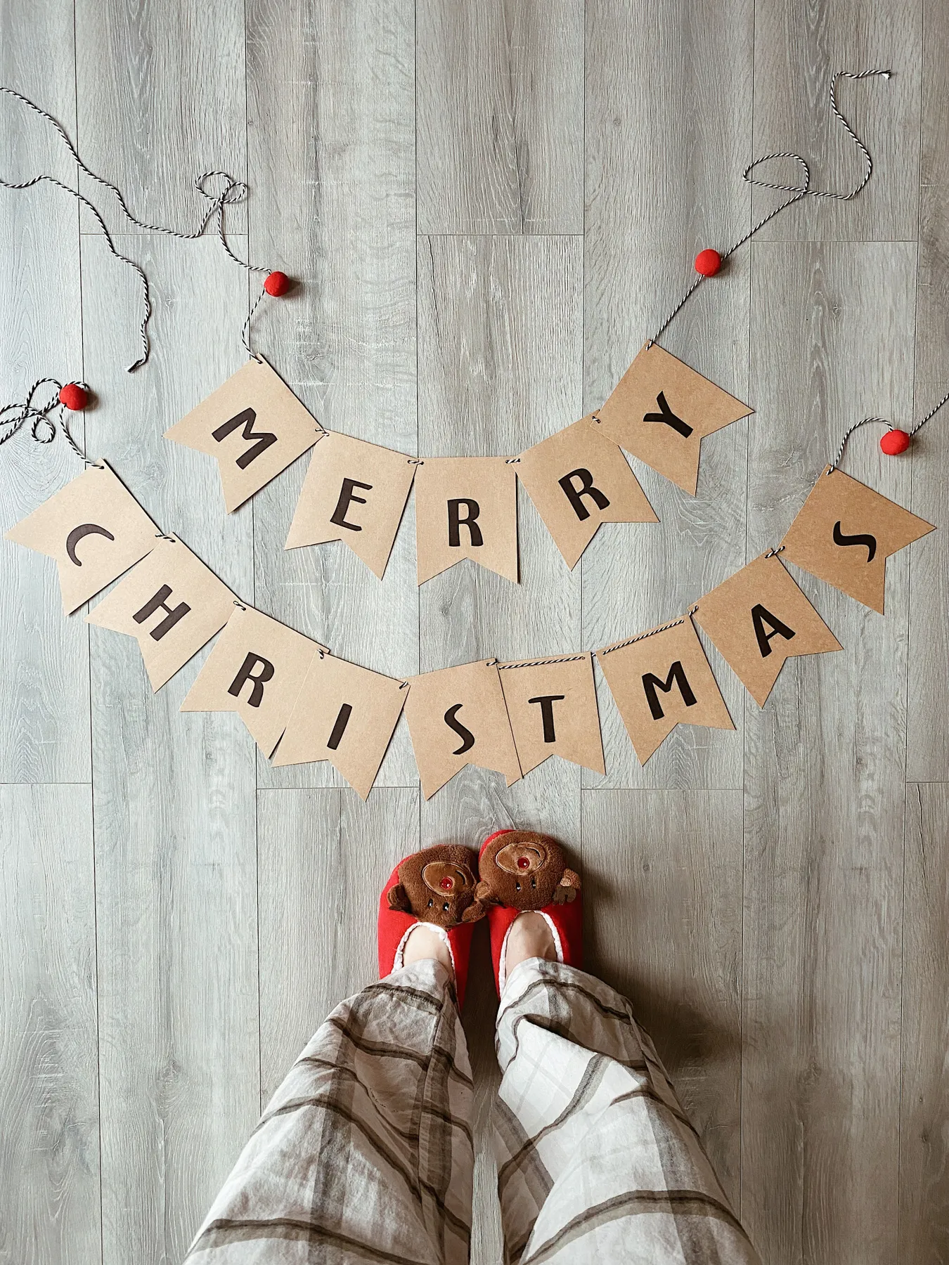 Top view of festive Merry Christmas banner with cozy socks on wooden floor, perfect for holiday themes.